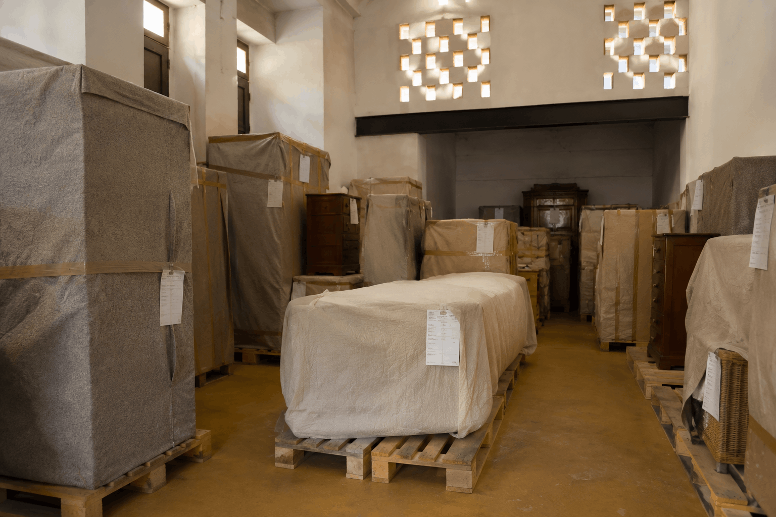 Muebles embalados con fundas y mantas de mudanza listos para guardar